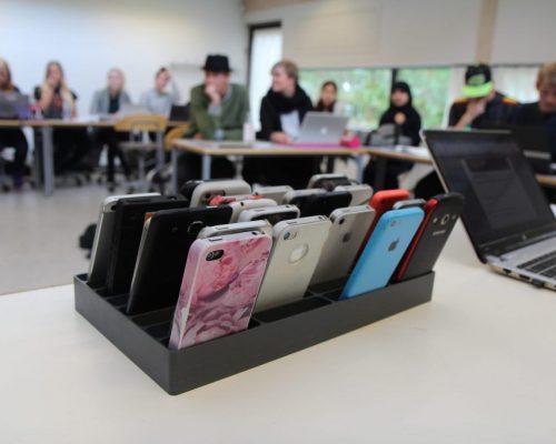 mobilramme fyldt med telefoner i klasselokale